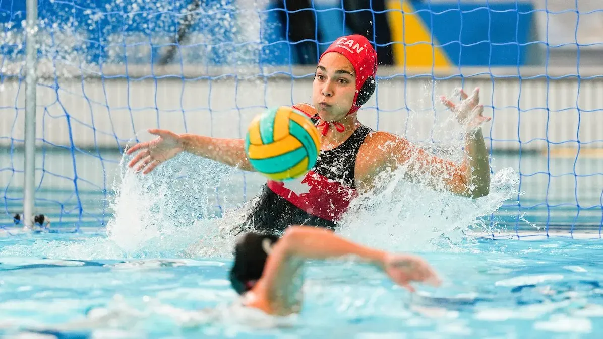 Photo d’une gardienne de but qui se prépare à faire un arrêt au water-polo.