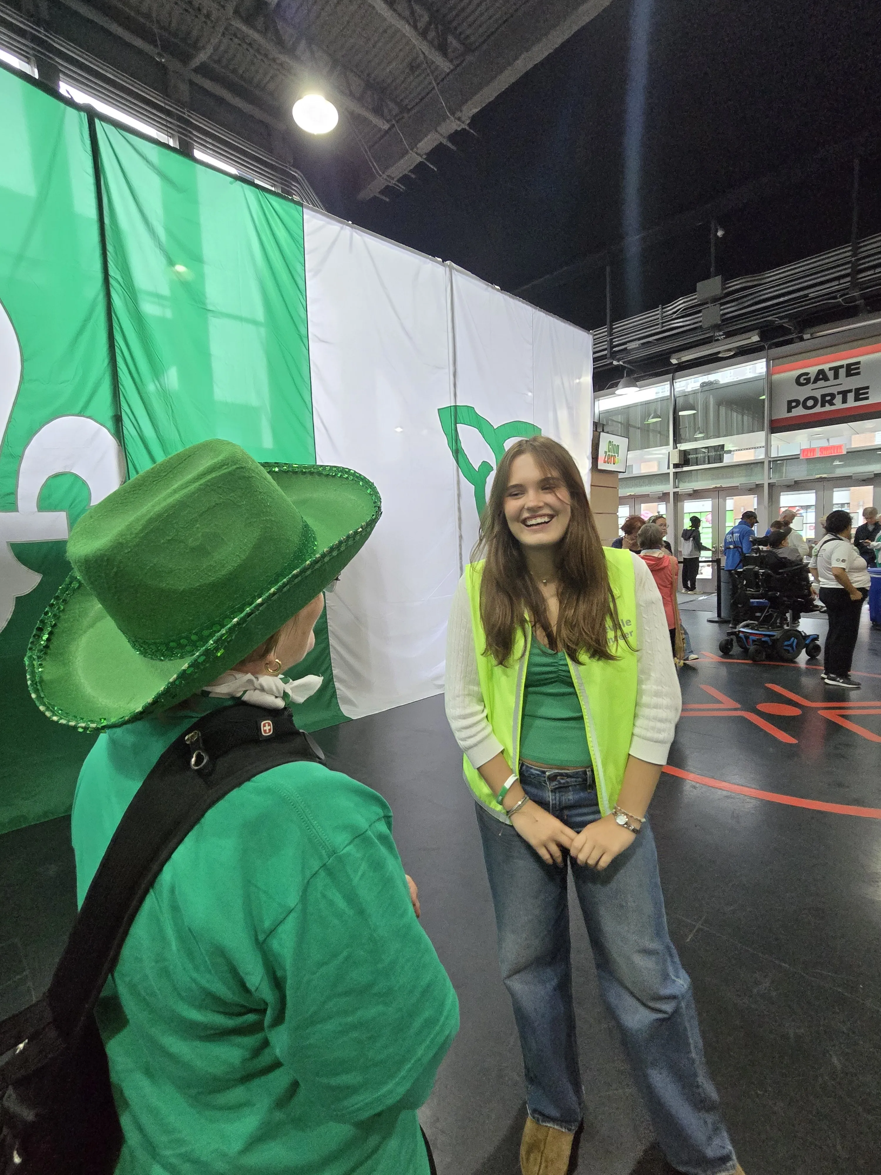 Sasha Gauthier et Roxanne Leblanc-Lemieux se tiennent debout face à face devant un grand drapeau franco-ontarien.